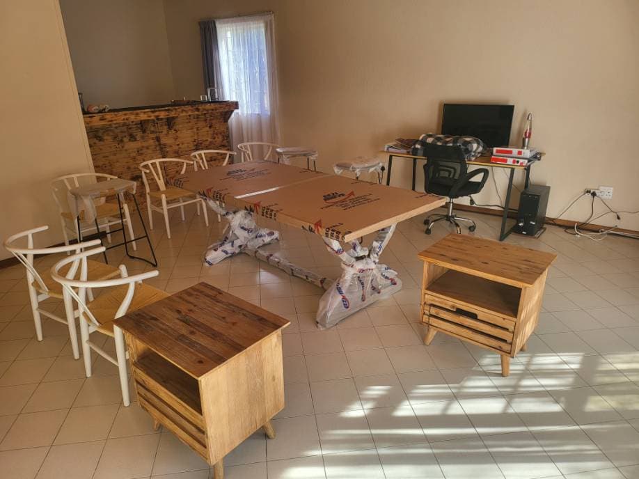 Delivered furniture standing in place in a customer's home — table, chairs and side tables unloaded and set down